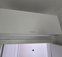 Légkondicionáló a falon egy villa belsejében, fehér dizájnnal és sima felülettel.