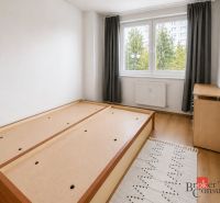 Világos hálószoba egy kétszobás lakásban, ággyal és fa dekorációjú padlóval.