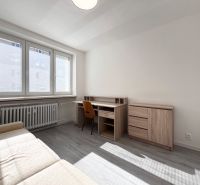 Nappali íróasztallal és kanapéval, fa dekorációjú padlóval egy háromszobás lakásban.