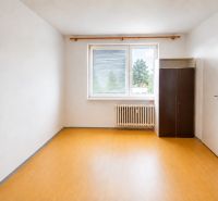 Üres szoba fa dekor padlóval, gardróbszekrénnyel és radiátorral egy kétszobás lakásban.
