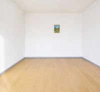 Üres szoba egy kétszobás lakásban, fa dekorációjú padlóval és fehér falakkal.