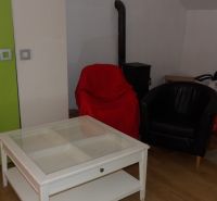 Nappali egy kétszobás lakásban, székekkel és asztallal, fa dekor padlón.