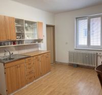 Konyha fa konyhabútorral és fa mintázatú padlóval a családi házban.