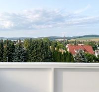 Kilátás a zöldre és a tetőkre Bánovce nad Bebravou-ban egy 2 szobás lakásból.