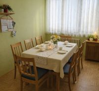 Ebédlő egy családi házban, megterített asztallal és fa dekorációjú padlóval.