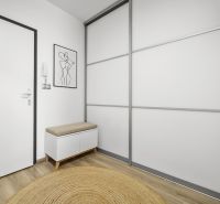 Előszoba egy kétszobás lakásban, fa dekor padlóval és minimalista bútorokkal.