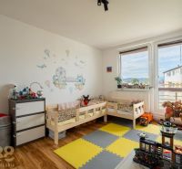 Gyerekszoba két ággyal és matricákkal egy háromszobás lakásban, fa dekoros padlóval.