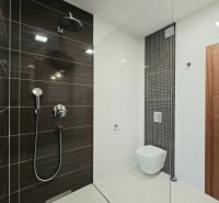 Fürdőszoba zuhanyzóval és függesztett WC-vel egy 4 szobás lakásban.