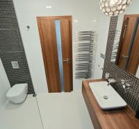 Fürdőszoba függesztett WC-vel, mosdóval és radiátorral egy 4 szobás lakásban.