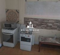 Konyha egy családi házban gáz tűzhellyel, mikrohullámú sütővel és dekoratív csempékkel a falon.