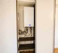 Beépített szekrény kazánnal a háromszobás lakásban, fa dekoros padló.