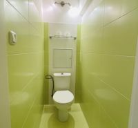 Keskeny fürdőszoba világoszöld csempékkel és WC-vel egy háromszobás lakásban.