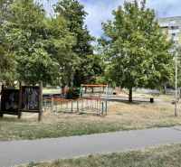 Játszótér fákkal körülvéve a Topoľčany város parkjában, közel egy egyszobás lakáshoz.