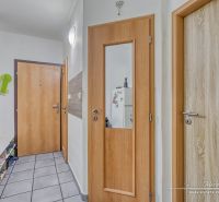 Folyosó egy kétszobás lakásban csempézett padlóval és faajtókkal.