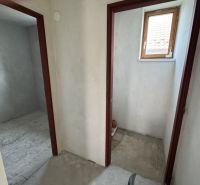 A családi házban két helyiség található betonpadlóval és kis ablakkal.