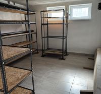 Fém polcokkal és csempével ellátott raktár családi házban.