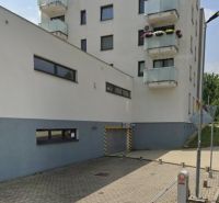 Épület garázzsal a Besztercebányai Švermova utcában, parkoló oszlopok.