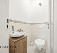 Fürdőszoba egy háromszobás lakásban mosdóval és WC-vel, dekoratív mintás csempékkel.