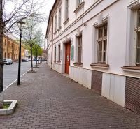 Františkánska utca Trnaván történelmi épületekkel és fákkal az irodák mellett.