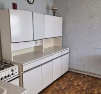 Konyha családi házban gáz tűzhellyel és fa dekorációjú padlóval.