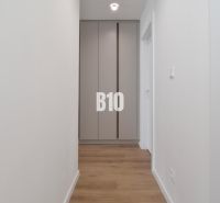 Folyosó beépített szekrénnyel és fa dekor padlóval egy 4 szobás lakásban.
