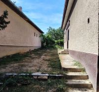 Családi ház Tardoskedden udvarral, ahol lépcső vezet a két épület között.
