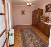 Családi ház belső tere fa dekor padlóval, szőnyeggel és szekrényekkel.