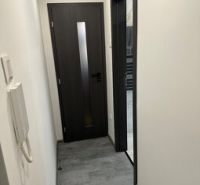 Folyosó egy kétszobás lakásban sötét ajtókkal és fali kaputelefonnal.
