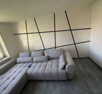 2 szobás lakás belső tere kényelmes kanapéval és fa dekorációjú padlóval.