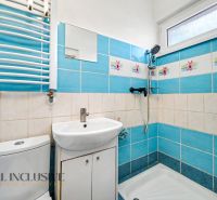 Fürdőszoba családi házban kék csempével és fehér berendezéssel.
