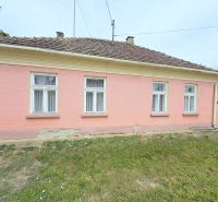 Családi ház Dunakilitiben rózsaszín homlokzattal és négy ablakkal a földszinten.