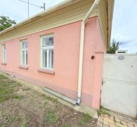 Családi ház Dunakilitiben rózsaszín homlokzattal, fehér ablakokkal és kapuval.