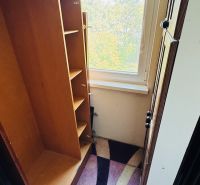 Háromszobás lakás gardróbja nagy ablakos kilátással és színes szőnyeggel.