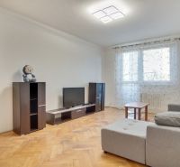 Nappali egy kétszobás lakásban, fa dekoros padlóval és világos belső térrel.