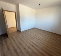 Szoba egy családi házban, fa dekorációjú padlóval és fa ajtókkal.