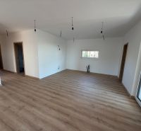 Családi ház belső tere fa dekorációjú padlóval és minimalista világítással.