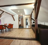 Nyaraló apartman fa dekorációjú padlóval, fa gerendákkal és kényelmes bútorokkal.