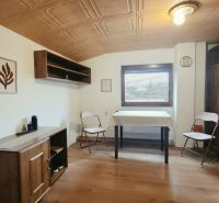 A fa dekorációjú bútorokkal és összecsukható székekkel berendezett üdülő apartman belső tere.