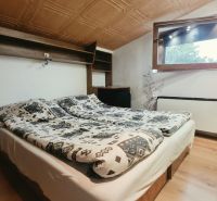 Tetőtéri hálószoba franciaággyal, polccal és ablakkal, Nyaraló apartman.