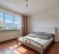 Hálószoba családi házban, ággyal és fa dekorációjú padlóval.