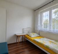 Egyágyas szoba ággyal és asztallal, fa dekorációjú padló, fehér belső tér.