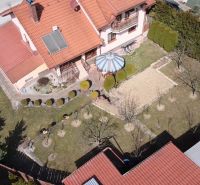 Családi ház Ólublón kerttel, gyepfelülettel, pavilonnal és napkollektorokkal a tetőn.