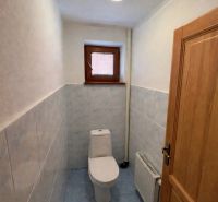 WC egy családi házban kék csempékkel és kis ablakkal.