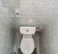 Kék csempés WC egy kétszobás lakásban, egyszerű belső tér.