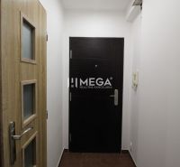 Rekreációs apartman bejárata világos falakkal és fa dekorációjú ajtókkal.