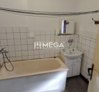 Fürdőszoba egy háromszobás lakásban káddal, mosdóval és fehér csempékkel.