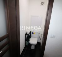 Kis WC a háromszobás lakásban sötét ajtókkal és fekete csempével.