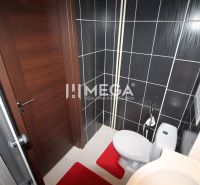Fürdőszoba a nyaraló apartmanban zuhanyzóval, WC-vel és fekete csempékkel.