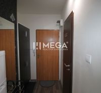 Nyaraló apartman folyosója fa dekor padlóval, tapétával és hűtőszekrénnyel.