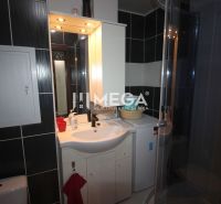 Fürdőszoba a nyaraló apartmanban zuhanyzóval, mosdóval és mosógéppel.